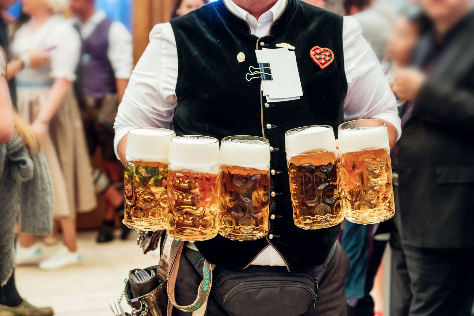 Oktoberfest waiter with armful of beer steins.